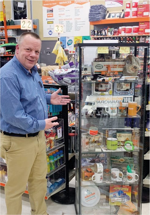 Pictured is Gates beside a showcase of Aubuchon Company collectibles.